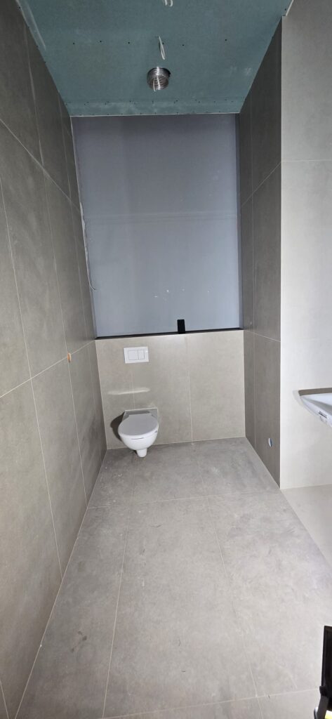 Strefa WC wykończona płytkami 120x60 w łazience w Zakopanem